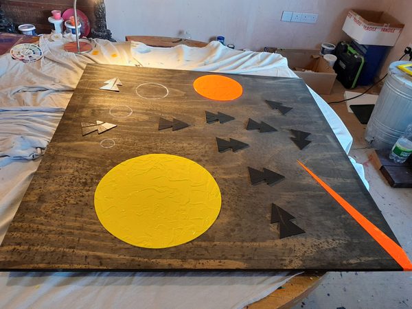 Studio view of geometric abstract artwork drying on easel