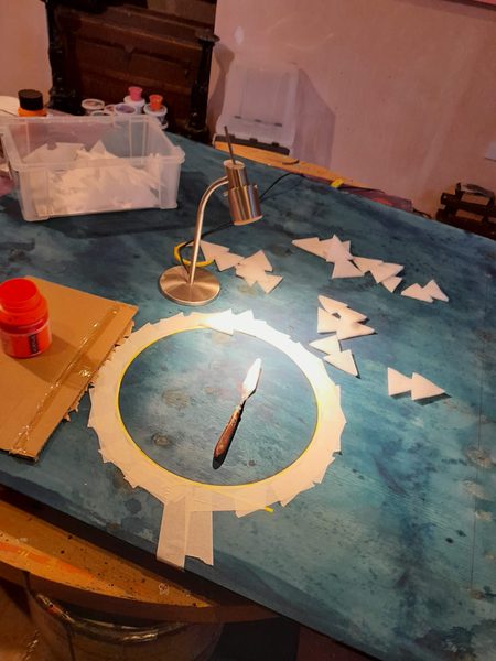 Final inspection of finished geometric abstract artwork in studio